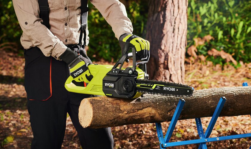 batteridriven motorsåg ryobi vid sågbock med trästam