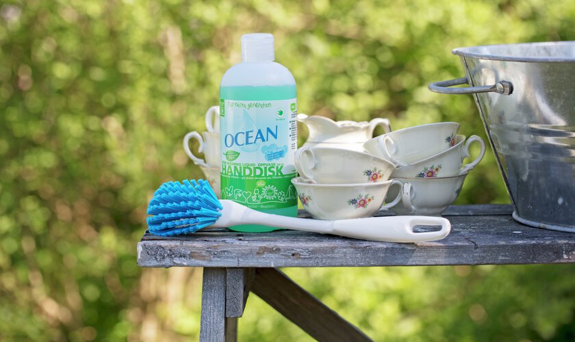 disk på träbänk med ocean handdiskmedel samt en diskborste och diskbalja