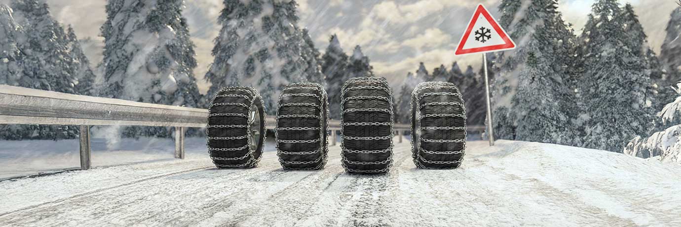 fyra däck med snökedjor på väg med is och snö